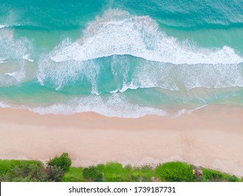 Aerial view top view Beautiful topical beach with white sand coconut palm trees and sea. Top view empty and clean beach. Waves crashing empty beach from above. With copy space.