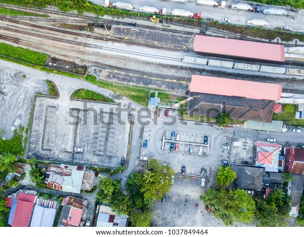 Aerial View - Top down view of car\
park and railway beside the rural houses in\
Malaysia