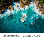 Aerial view Top down seashore. Waves crashing on rock cliff. Beautiful dark sea surface in sunny day summer background Amazing seascape top view seacoast at Intendance Beach, Mahe Seychelles