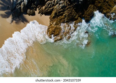 Aerial view Top down seashore wave crashing on rocks stones seashore Beautiful turquoise sea surface in sunny day Good weather day summer background.
