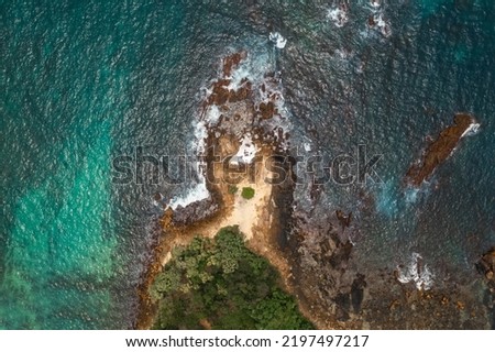 Aerial view Top down seashore big wave crashing on rock cliff Beautiful dark sea surface in sunny day summer background Amazing seascape top view seacoast at Phuket Thailand. High quality photo