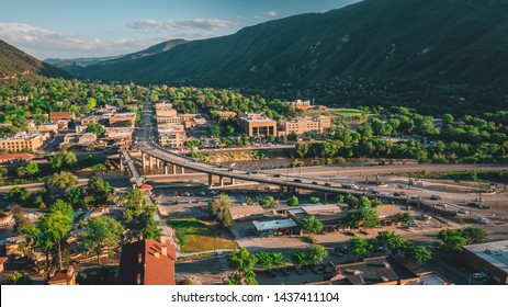 Aerial View Of The Town Of Glenwood Springs, Colorado In The Roaring Fork Valley And The Grand Avenue Bridge Going Over The Colorado River.