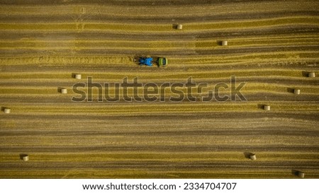 Similar – A combine harvester is harvesting grain crops on a cornfield in the evening sun seen from above