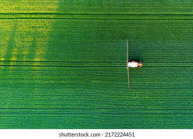 Aerial view of a tractor spraying agricultural fields. spraying herbicides on the field - Powered by Shutterstock