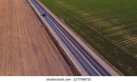 Aerial View Of Traffic On Two Lane Road Through Countryside And Cultivated Fields