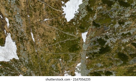 Aerial View Of Trail In The Mountain With Snow On The Slope