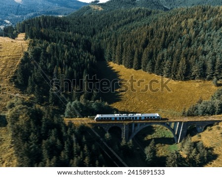 Aerial view of train on historical stone railway bridge in Slovakia. High, fully preserved stone arch railway bridge.