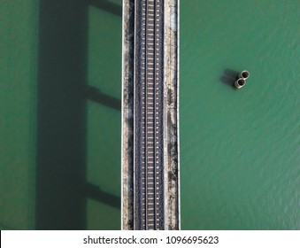 Aerial view of train railway over the river in Thailand. Top view of railroad from drone.