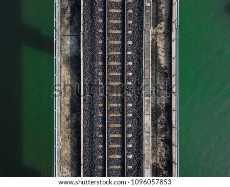 Aerial view of train railway over the river. Top view of railroad from drone.