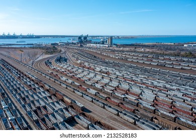 Aerial View Of A Train Yard Near The River With Many Rail Cars