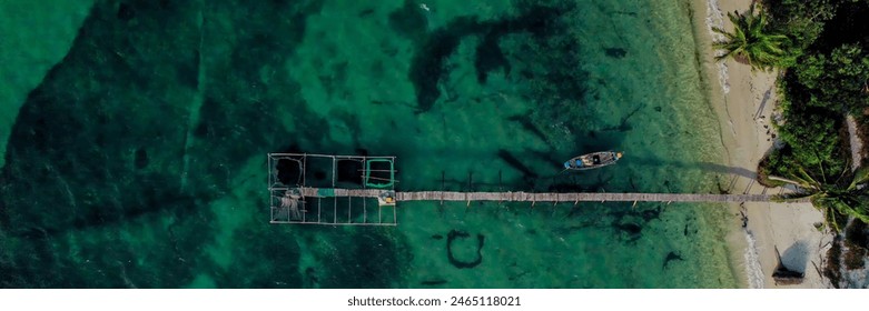 Aerial view of a tranquil wooden pier with a gazebo over clear turquoise waters, ideal for travel, relaxation, and World Oceans Day themes - Powered by Shutterstock