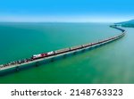 Aerial view of Travel train parked on a floating railway bridge over the clear water of lake in Pa Sak Jolasid dam with blue sky at Lopburi, amazing Thailand.	
