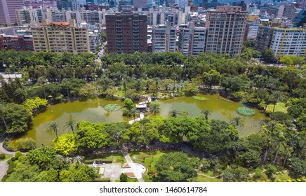 Aerial View Of Trees In Taipei Park Garden And Reflection Of Skyscrapers Buildings. Green Area In Smart Urban City At Noon, Taiwan.