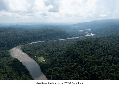 Aerial view of a tropical forest with a small community visible - Powered by Shutterstock