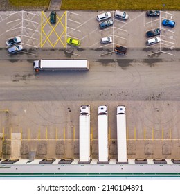 Aerial View Of Trucks Loading In The Distribution Hub. Logistics Center In Industrial City Zone From Top Down View. Background Texture Concept.