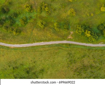 Aerial view of twisting road among the forest and trees. Sunset field in Lithuania. - Powered by Shutterstock
