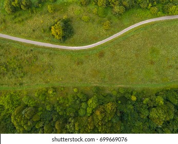 Aerial view of twisting road among the forest and trees. Sunset field in Lithuania. - Powered by Shutterstock
