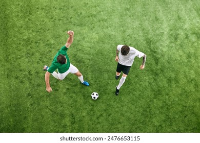 Aerial view. Two players in white and green uniforms battle for the ball on green lush playground. Concept of professional sport, championship, final match, movement. Ad - Powered by Shutterstock