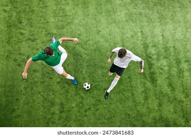 Aerial view. Two soccer players in attack position, fight for ball in motion on green lush playground. Concept of professional sport, championship, final match, movement. Ad - Powered by Shutterstock