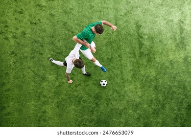 Aerial view. Two young me, soccer players competing for possession of ball on green lush playground. Concept of professional sport, championship, final match, movement. Ad - Powered by Shutterstock