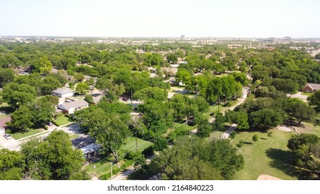 Aerial View Typical Residential Neighborhood Surrounded By Park And Lush Green Trees With Downtown Buildings In Background In Richardson, Texas, USA. North Texas Subdivision And Urban Sprawl