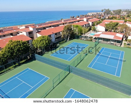 Aerial view of typical south california community condo with tennis court and pool next to the sea on the edge of the cliff during sunny day. Solana Beach. USA