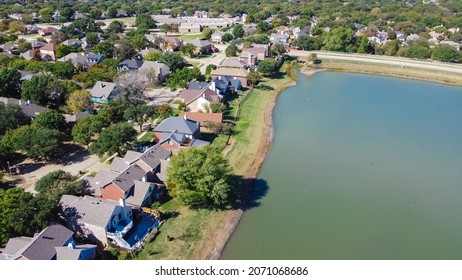 Aerial view upscale lakeside house in Flower Mound, Texas, America. Row of two story waterfront residential homes with mature trees near suburb Dallas