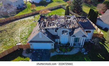 Aerial view upscale residential neighborhood with burnt house between other two story homes in Rochester, New York. Property totally damaged by fire disaster, insurance claim background