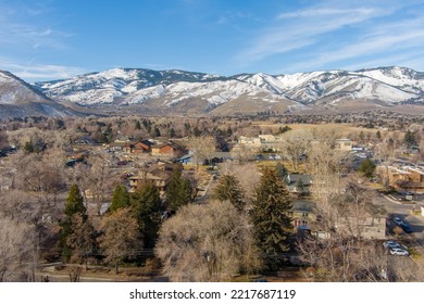 Aerial View Of The Urban Carson City Nevada Area With Snow Capped Mountains And Barren Trees In Early Winter.