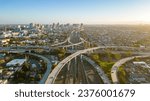 Aerial view of urban highway intersection and sprawling cityscape, roads and elevated bridges converge in the bustling metropolitan skyline, transportation network and urban planning