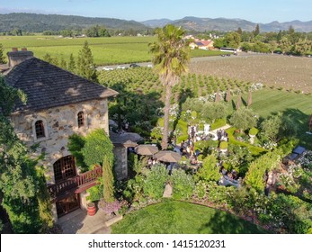 Aerial View Of V. Sattui Winery And Retail Store, St. Helena, Napa Valley, California, USA. People Enjoying Drink And Wedding Event In The Green Garden Surrounded By Vineyard 05/18/2019. 