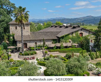 Aerial View Of V. Sattui Winery And Retail Store, St. Helena, Napa Valley, California, USA. People Enjoying Drink And Wedding Event In The Green Garden Surrounded By Vineyard 05/18/2019. 