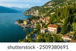 An aerial view of Varenna, a renowned tourist destination on the shores of Lake Como, Italy, captured by a drone. This famous village is celebrated for its colorful buildings, historic sites