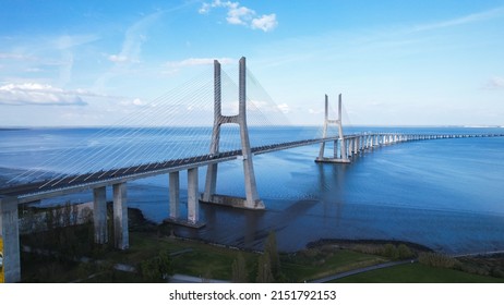 Aerial view of the Vasco da Gama Bridge is a cable-stayed bridge located in the city of Lisbon in Portugal and crosses the Tagus River. It is the second-longest bridge in Europe. - Shutterstock ID 2151792153