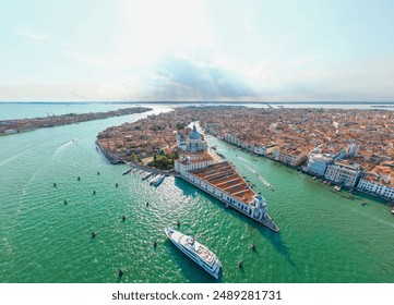 An aerial view of Venice, Italy, showcasing the Grand Canal, historic buildings, and boats on a sunny day - Powered by Shutterstock