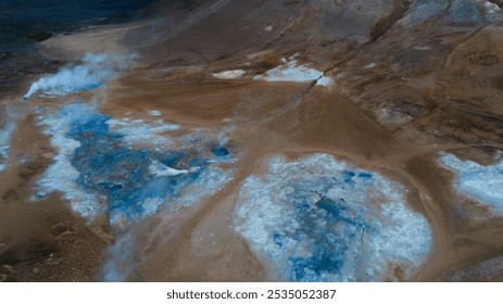 Aerial view of a vibrant geothermal sulfuric field in Iceland, showcasing vivid blue and brown mineral deposits, contrasting the natural textures of the earth. A striking alien landscape. - Powered by Shutterstock