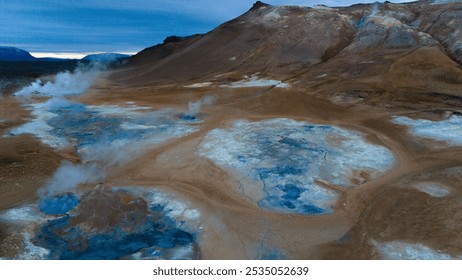 Aerial view of a vibrant geothermal sulfuric field in Iceland, showcasing vivid blue and brown mineral deposits, contrasting the natural textures of the earth. A striking alien landscape. - Powered by Shutterstock