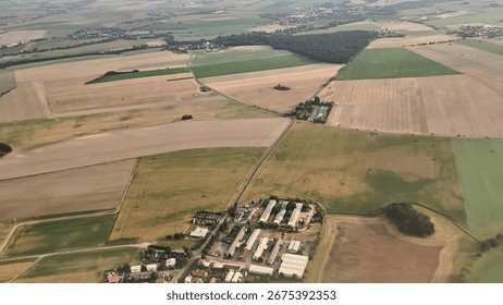 Aerial view of vibrant patchwork fields and wellkept farmland showcasing rural development and life