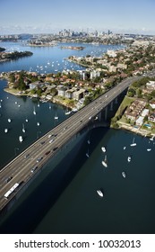 Aerial View Of Victoria Road Bridge And Boats With Distant Downtown Skyline In Sydney, Australia.