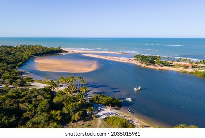 Aerial view of the village of Caraíva in Porto Seguro in southern Bahia. Tropical paradise with boats and umbrellas in tropical Brazil sunset.