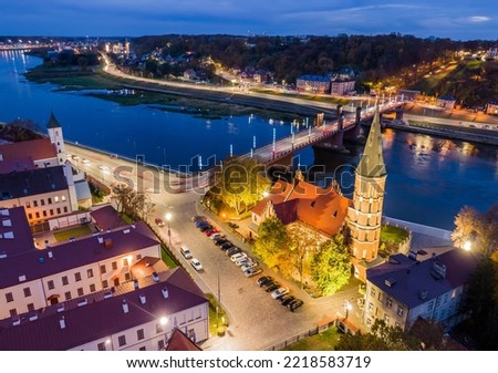 Aerial view of Vytautas the Great church in Kaunas old town during autumn evening with street and building illuminations.