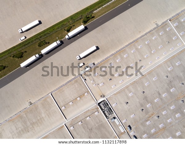 Aerial view of warehouse with trucks.\
Industrial background. Logistics from above.\
