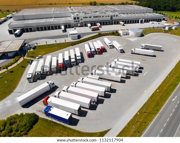Aerial view of warehouse with trucks.\
Industrial background. Logistics from above.\
