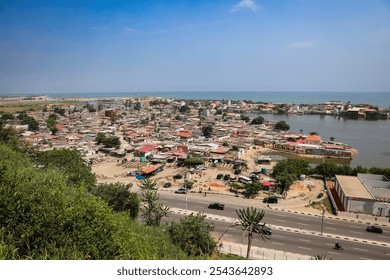 Aerial view of waterfront community in Luanda Angola showcasing vibrant homes and a scenic coastline under a clear blue sky - Powered by Shutterstock