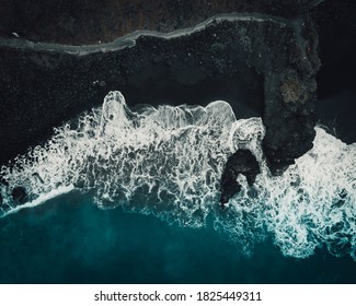 Aerial view of waves crashing on a black beach in Tenerife
