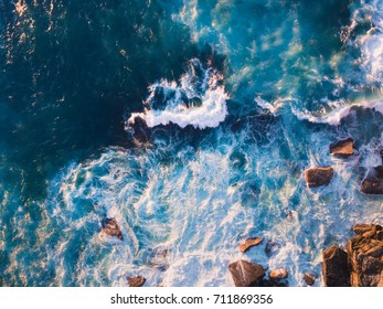 Aerial view of waves and some of rocks.