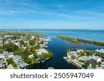 Aerial view of wealthy waterfront neighborhood. Expensive mansions between green palm trees on Gulf of Mexico shore in island small town Boca Grande on Gasparilla Island in southwest Florida, USA.