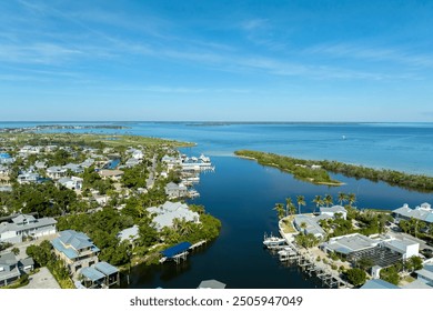 Aerial view of wealthy waterfront neighborhood. Expensive mansions between green palm trees on Gulf of Mexico shore in island small town Boca Grande on Gasparilla Island in southwest Florida, USA. - Powered by Shutterstock