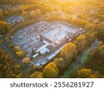 Aerial view of a well known British supermarket store and large carpark. Seen at dusk during early winter.