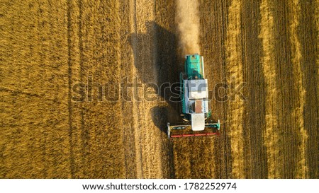 Similar – Image, Stock Photo Mähdräscher harvests a grain field in the evening light from the air